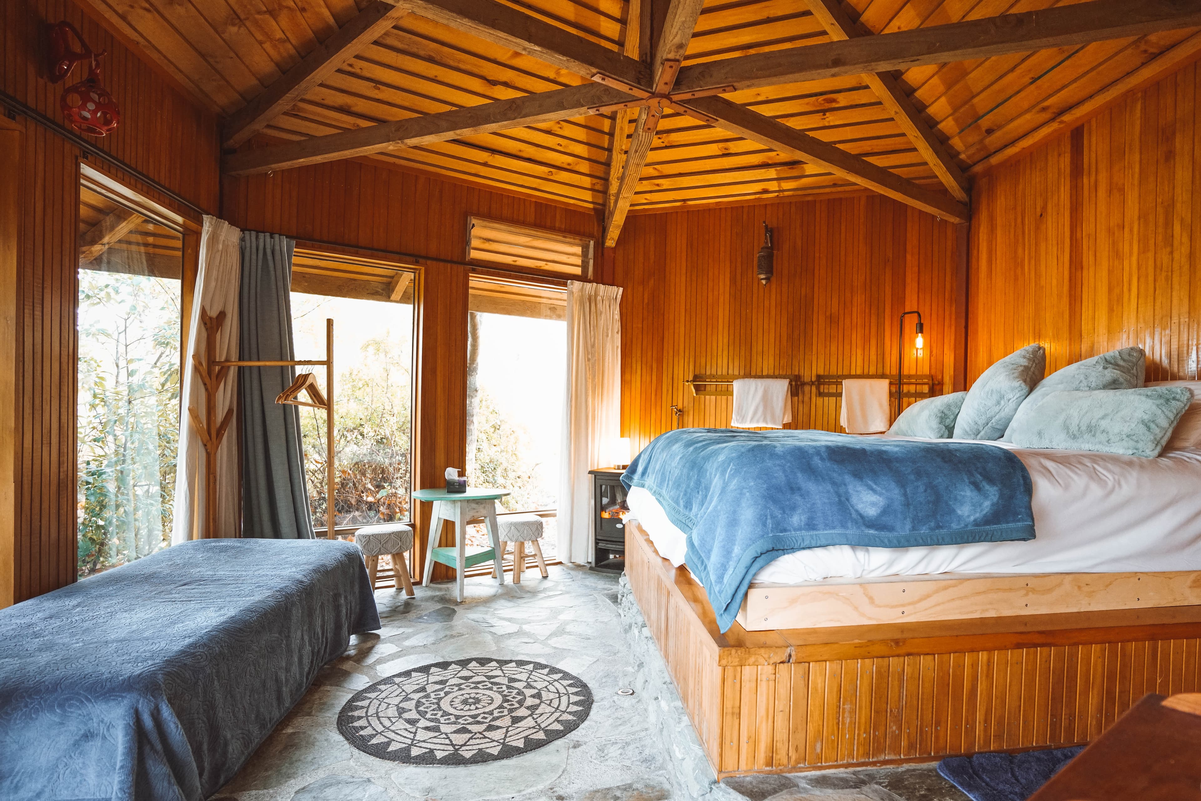 Cozy wooden cabin bedroom with warm timber and blue bedding